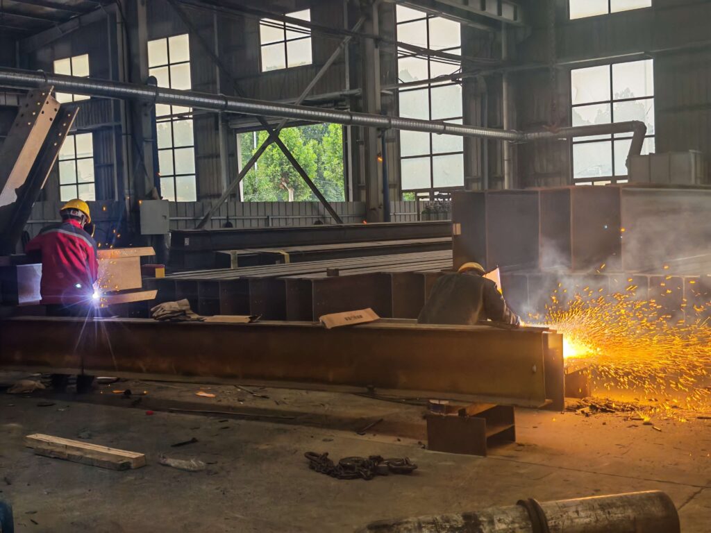 Internationally certified welders are welding steel structures at the SynJect steel structure production workshop.